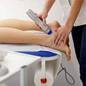 Doctor treating a patient's ankle with lasers