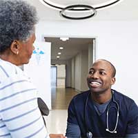 Young black doctor listening to his senior patient